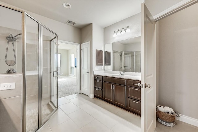 full bathroom with vanity, baseboards, visible vents, a shower stall, and tile patterned floors