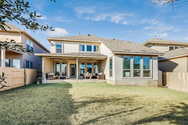 rear view of house featuring a lawn, a fenced backyard, ceiling fan, a patio area, and stucco siding