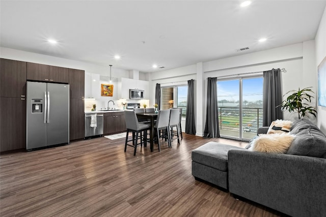 interior space featuring dark brown cabinets, stainless steel appliances, light countertops, and open floor plan