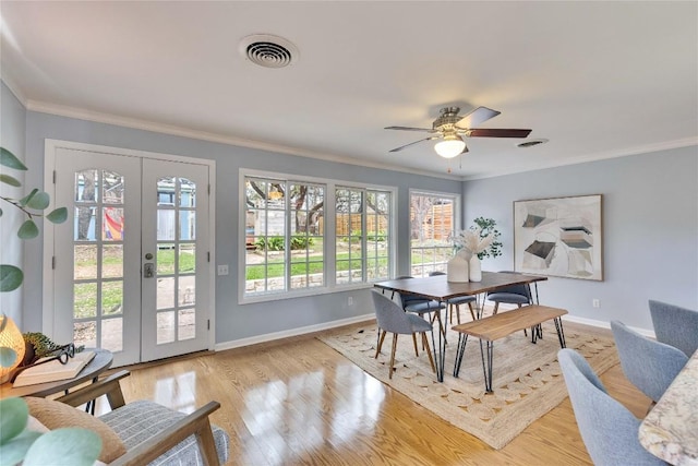 dining area with french doors, light wood-style flooring, visible vents, and crown molding