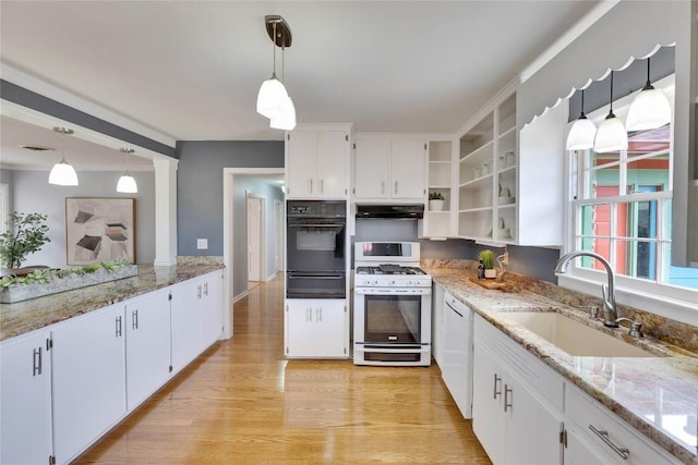 kitchen featuring stainless steel range with gas cooktop, pendant lighting, oven, and a sink