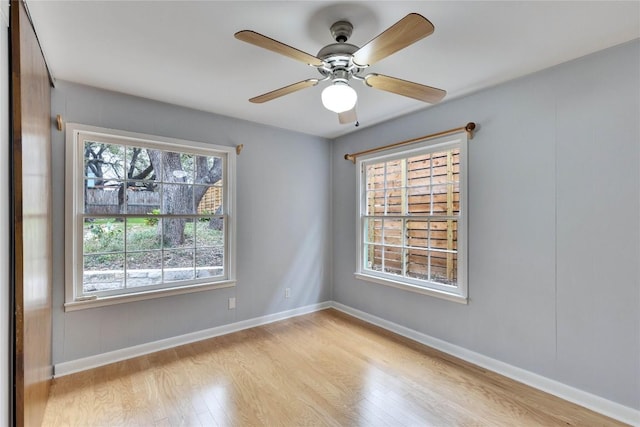 empty room featuring light wood-style floors, ceiling fan, and baseboards