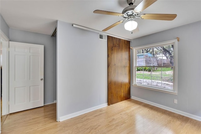 unfurnished bedroom with ceiling fan, light wood-type flooring, visible vents, and baseboards