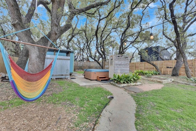 view of yard featuring a fenced backyard and a hot tub