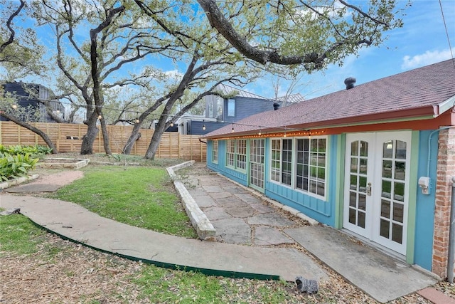 view of yard featuring french doors and a fenced backyard