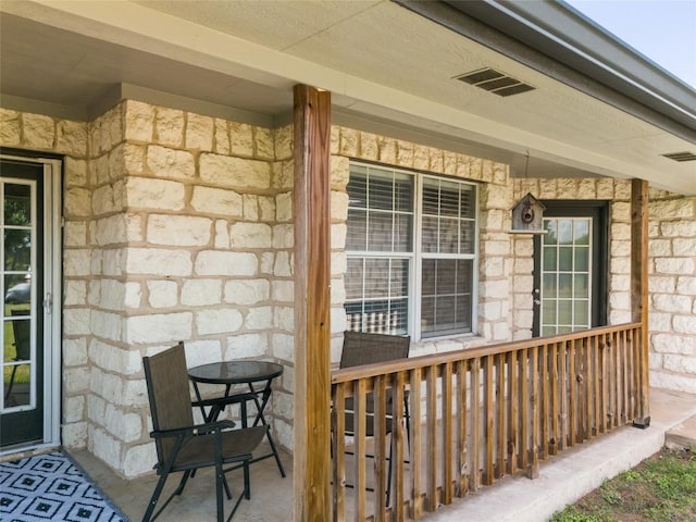 doorway to property with stone siding and visible vents