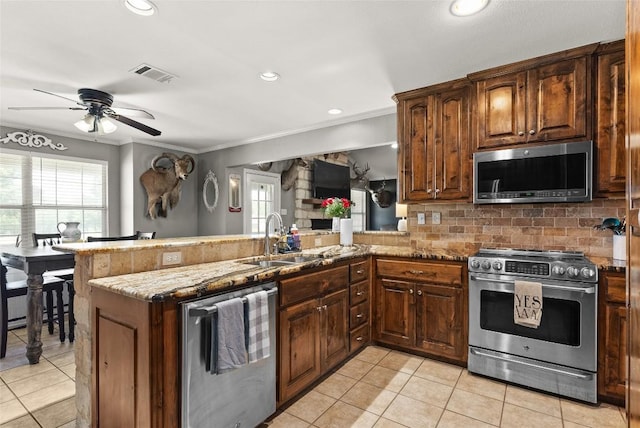 kitchen with stainless steel appliances, a peninsula, a sink, and visible vents