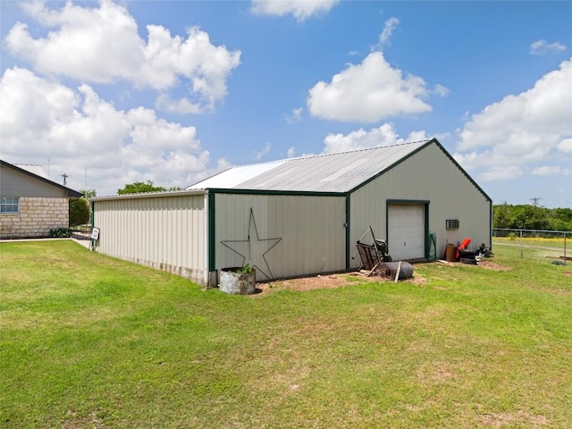 view of pole building with a lawn, driveway, and fence