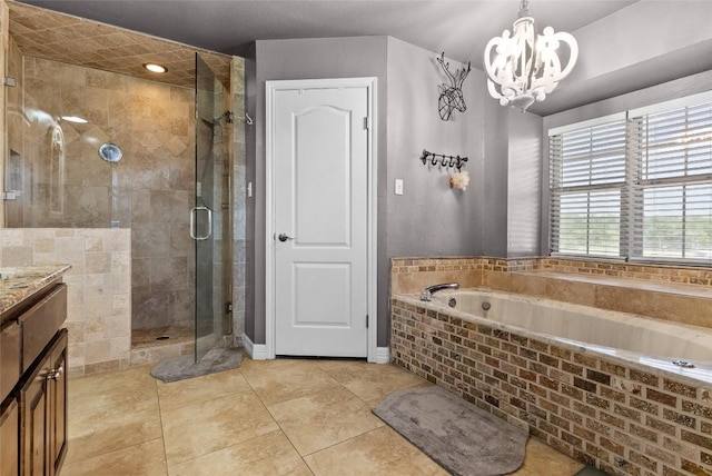 bathroom featuring a garden tub, a notable chandelier, vanity, tile patterned floors, and a stall shower