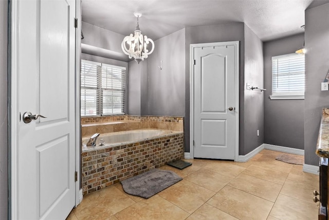 bathroom featuring baseboards, plenty of natural light, an inviting chandelier, and tile patterned floors