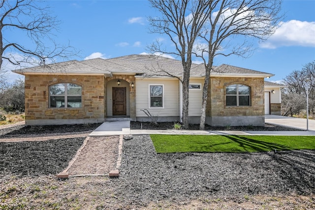 view of front facade with stone siding, a shingled roof, concrete driveway, and a front yard