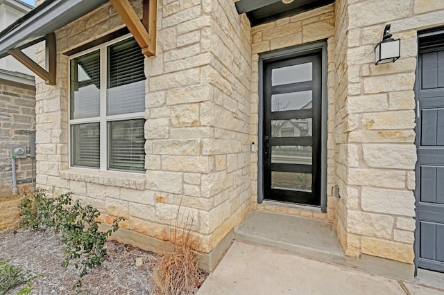 property entrance featuring stone siding