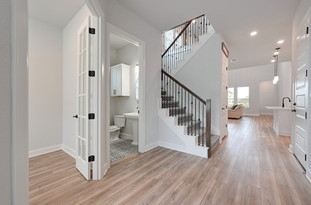 stairway featuring recessed lighting, baseboards, and wood finished floors