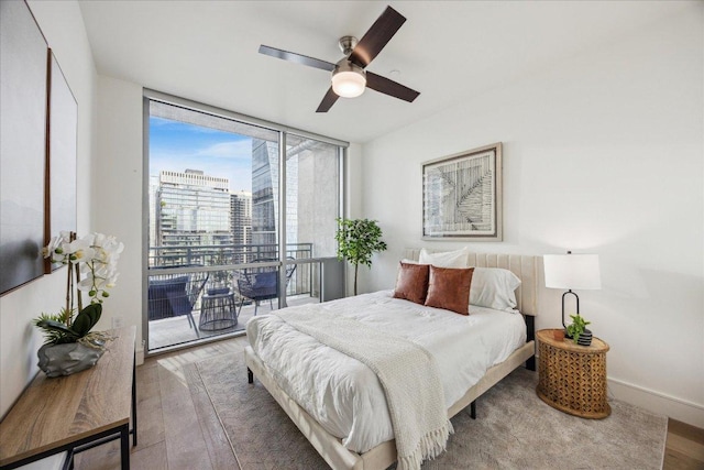222 W Ave Unit 2403, Austin, TX 78701 - bedroom with wood finished floors, expansive windows, ceiling fan, and access to exterior