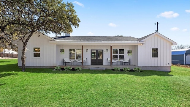 view of front of property with covered porch, a front yard, board and batten siding, and french doors