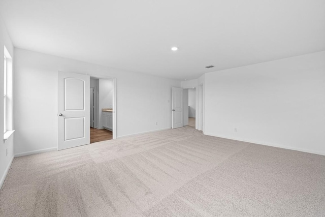 unfurnished bedroom with light carpet, recessed lighting, visible vents, and baseboards