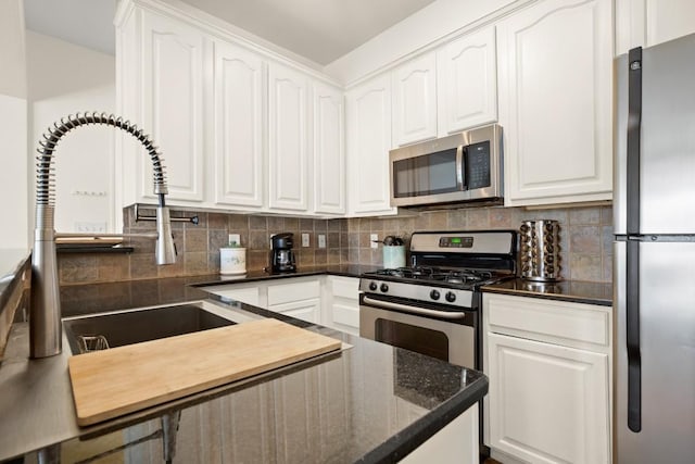 kitchen with white cabinetry, appliances with stainless steel finishes, and tasteful backsplash