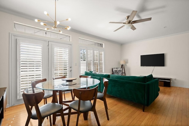 dining area with light wood-style floors, crown molding, and ceiling fan with notable chandelier