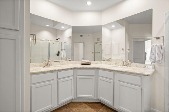 bathroom featuring a stall shower, a sink, recessed lighting, and double vanity