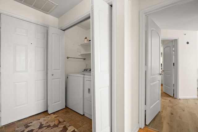 laundry area featuring laundry area, separate washer and dryer, visible vents, baseboards, and light wood finished floors