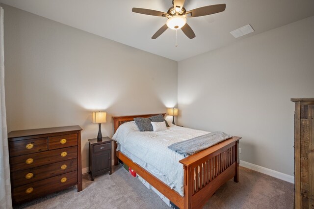 bedroom featuring a ceiling fan, light carpet, visible vents, and baseboards