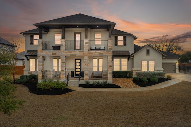 view of front of home featuring a standing seam roof, stone siding, metal roof, and stucco siding