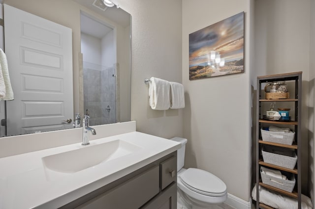 bathroom with baseboards, visible vents, tiled shower, toilet, and vanity
