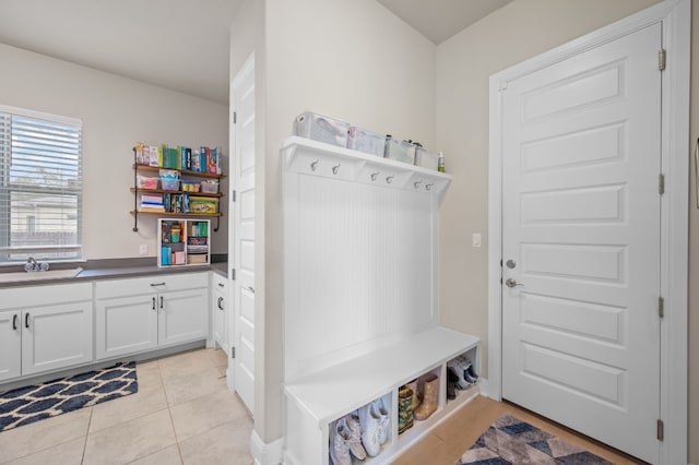 mudroom featuring light tile patterned flooring and a sink