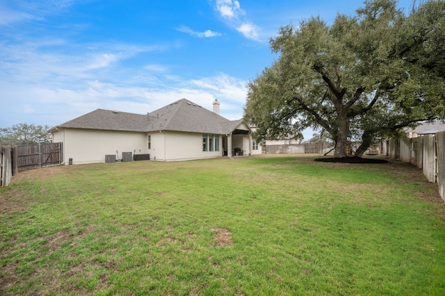view of yard with a fenced backyard and central AC