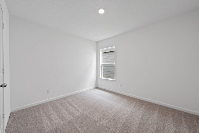 empty room with carpet and baseboards