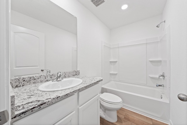 full bathroom with shower / bathtub combination, visible vents, toilet, vanity, and wood finished floors