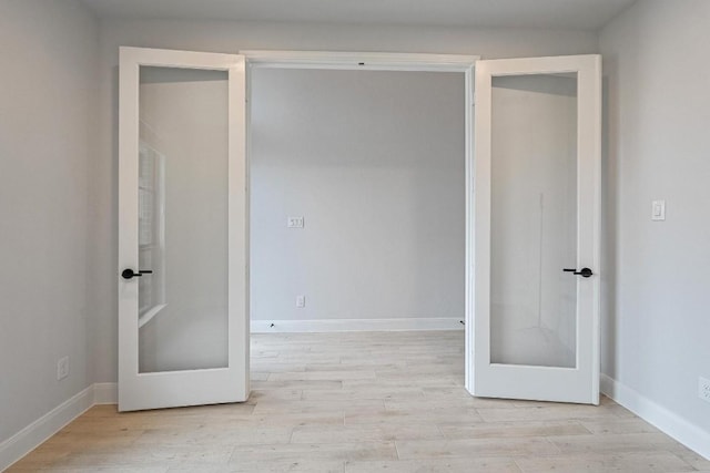 spare room featuring light wood-type flooring and baseboards