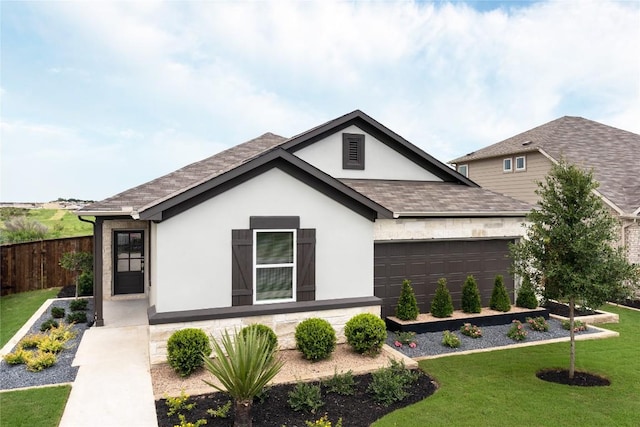 ranch-style home featuring a garage, fence, roof with shingles, stucco siding, and a front lawn