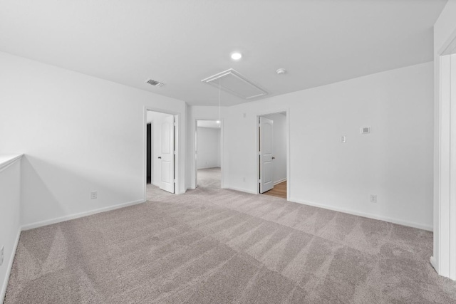 spare room featuring recessed lighting, light colored carpet, visible vents, baseboards, and attic access