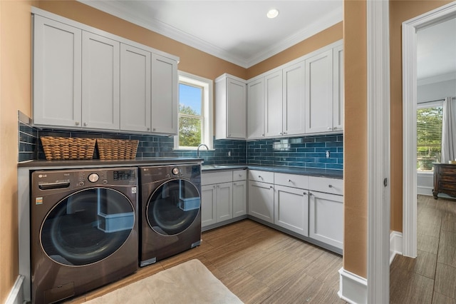 20201 Hickory Grove Ln, Manor, TX 78653 - washroom featuring separate washer and dryer, cabinet space, crown molding, and wood finished floors