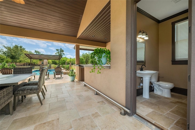 view of patio with an outdoor pool and a sink