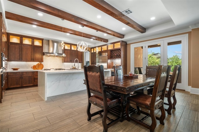 dining space featuring french doors, visible vents, and beamed ceiling
