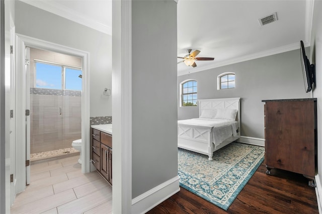 bedroom with light wood-style floors, visible vents, and crown molding