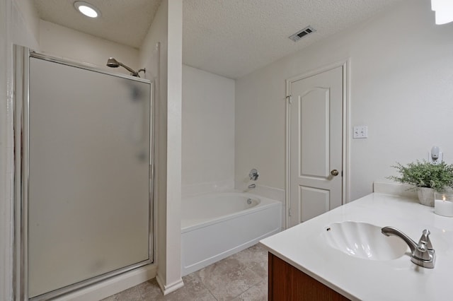 bathroom with visible vents, a textured ceiling, vanity, a shower stall, and a bath