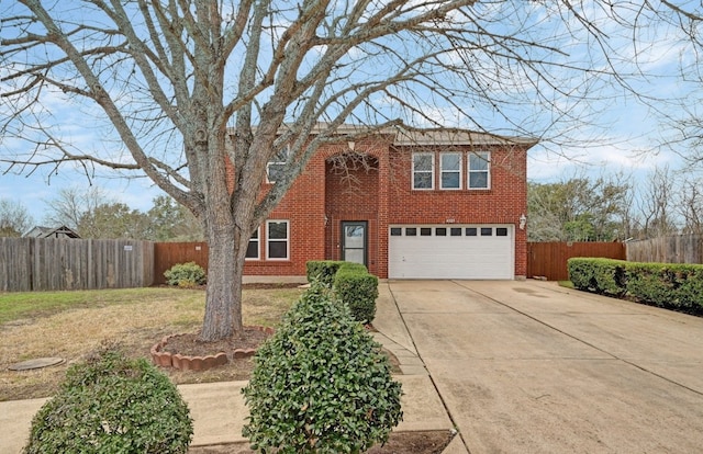 traditional-style house with a garage, driveway, brick siding, and fence