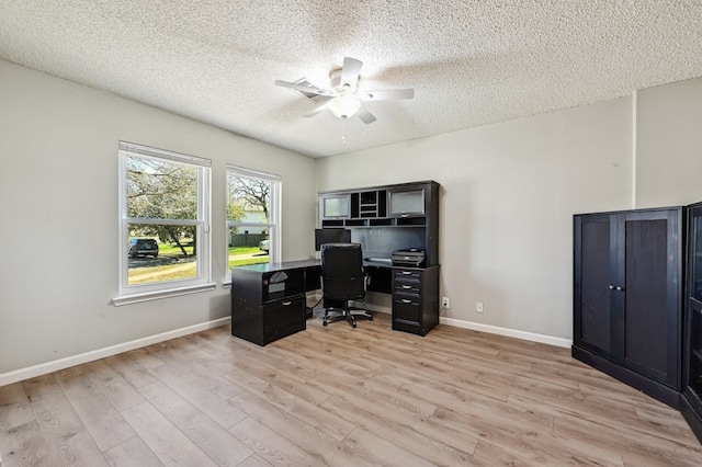 office area featuring baseboards, ceiling fan, a textured ceiling, and light wood finished floors