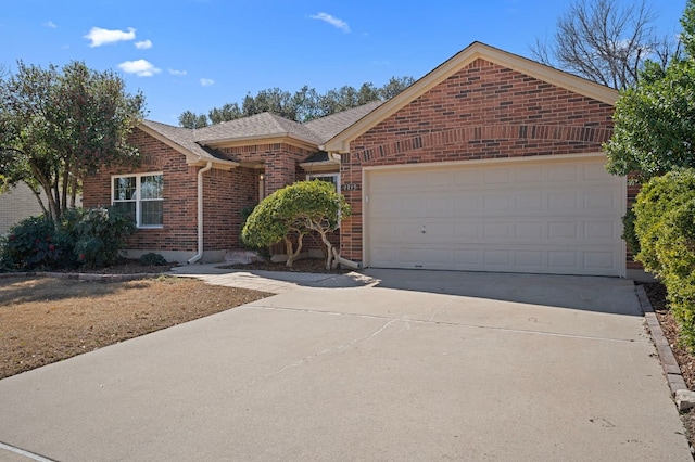 ranch-style home with an attached garage, a shingled roof, concrete driveway, and brick siding