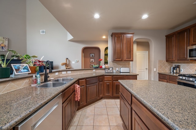605 Hickory Run Dr, Cedar Park, TX 78613 - kitchen with arched walkways, appliances with stainless steel finishes, decorative backsplash, light stone countertops, and recessed lighting