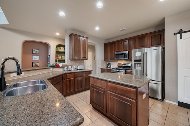 605 Hickory Run Dr, Cedar Park, TX 78613 - kitchen featuring appliances with stainless steel finishes, a sink, arched walkways, tasteful backsplash, and recessed lighting