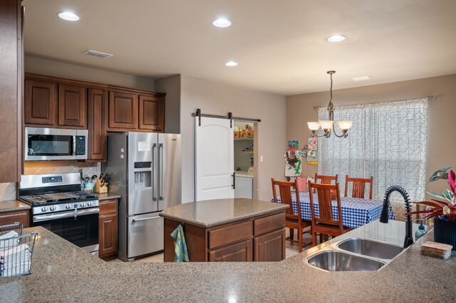 605 Hickory Run Dr, Cedar Park, TX 78613 - kitchen featuring appliances with stainless steel finishes, a barn door, decorative backsplash, recessed lighting, and a center island