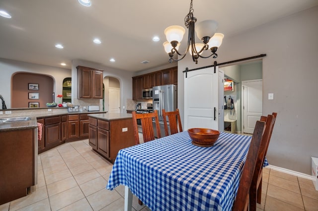 605 Hickory Run Dr, Cedar Park, TX 78613 - dining space with arched walkways, a barn door, light tile patterned floors, a chandelier, and recessed lighting
