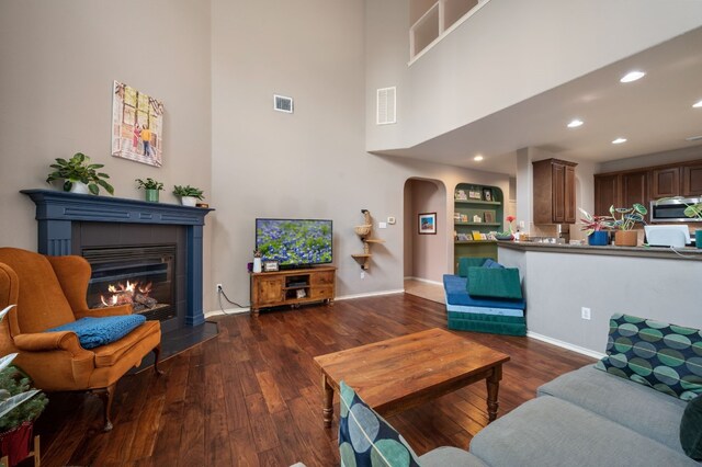 605 Hickory Run Dr, Cedar Park, TX 78613 - living area featuring a high ceiling, wood finished floors, a tile fireplace, recessed lighting, and arched walkways