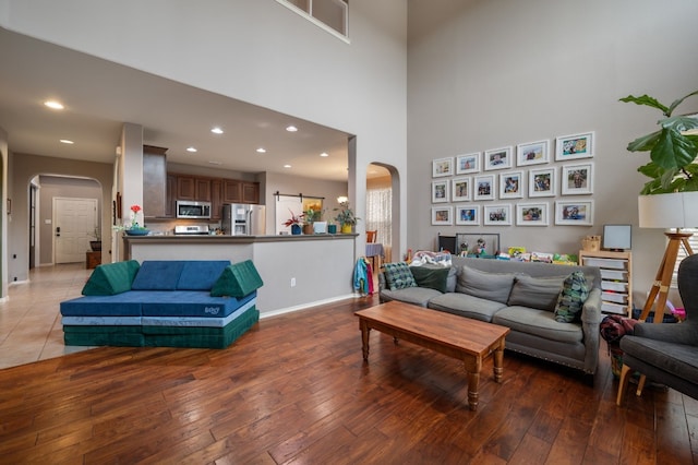 605 Hickory Run Dr, Cedar Park, TX 78613 - living area featuring arched walkways, wood-type flooring, recessed lighting, and a towering ceiling