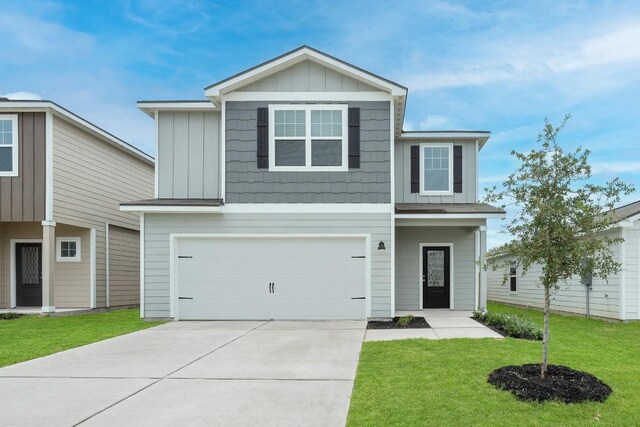 view of front of home with a garage, driveway, board and batten siding, and a front yard