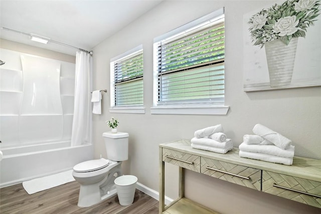 bathroom with toilet, baseboards, shower / bathtub combination with curtain, and wood finished floors